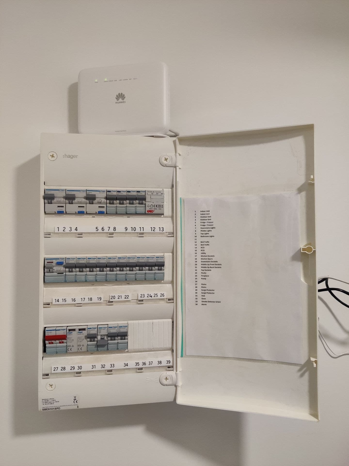 Modern Hager consumer unit with hinged door open, breakers and blanked spaces visible