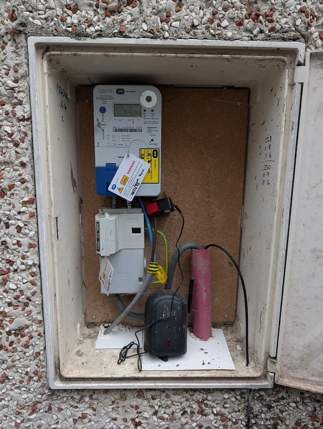 Open external meter cabinet showing smart meter, main fuse, isolator and outgoing tails